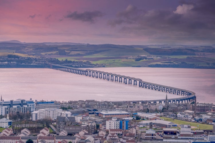 photo of view of From the monument at Dundee law Hill looking down over the city to the Fourth or Tay Railway Bridge Dundee Scotland at sunset.