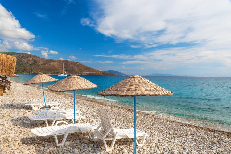 Photo of sun loungers and umbrellas on Palamutbuku beach in Datca Peninsula, Mugla region, Turkey.