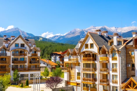 Photo of Bansko, Bulgaria summer view with houses and Pirin peaks panorama.