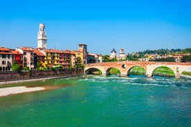 Photo of aerial view of Verona historical city centre, Ponte Pietra bridge across Adige river, Verona Cathedral, Duomo di Verona, red tiled roofs, Veneto Region, Italy.