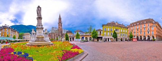 Photo of Italy Piazza Maggiore in Bologna old town tower of town hall with big clock and blue sky on background, antique buildings terracotta galleries.