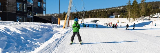 photo of beautiful vibrant aerial winter mountain view of ski resort Trysil, Norway. sunny winter day with slope, piste and ski lift.