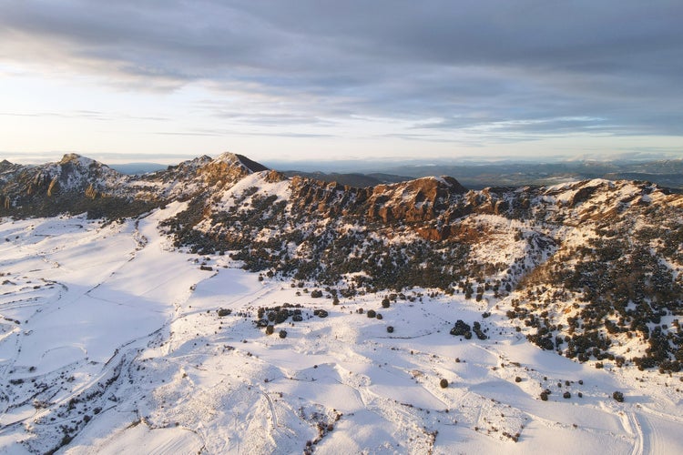 photo of view of Aerial view of snow covered mountains at sunset in Obarenes mountain range, Burgos province, Spain.