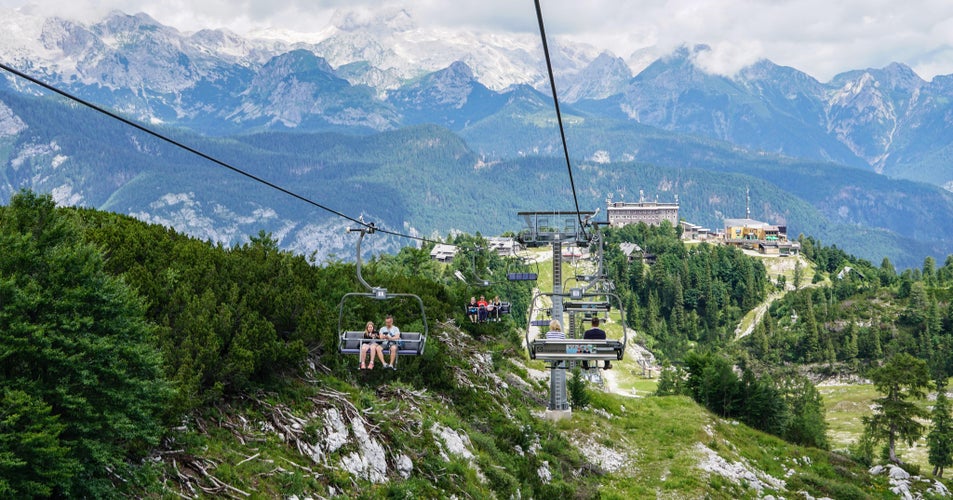 People riding a chairlift at Vogel Ski Center with views of the Julian Alps in Slovenia..jpg