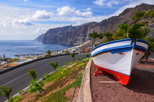 photo of aerial shot of Costa Adeje area, South Tenerife, Spain. Captured at golden hour, warm and vivid sunset colors. Luxury hotels, villas and restaurants behind the beach.