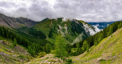 Photo of aerial view of the city of Lermoos, Austria with the Alps mountains in the background on a sunny summer day.