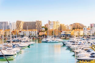 photo of an aerial view of wide sandy beach in touristic resorts of Quarteira and Vilamoura, Algarve, Portugal.