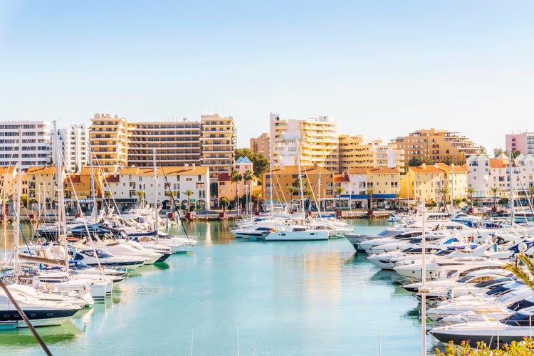 Photo of marina full of luxurious yachts in touristic Vilamoura, Quarteira, Algarve, Portugal.