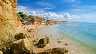 Photo of wide sandy beach in white city of Albufeira, Algarve, Portugal.