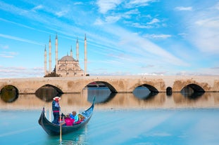 Touristic sightseeing ships in Golden Horn bay of Istanbul and mosque with Sultanahmet district against blue sky and clouds. Istanbul, Turkey during sunny summer day.