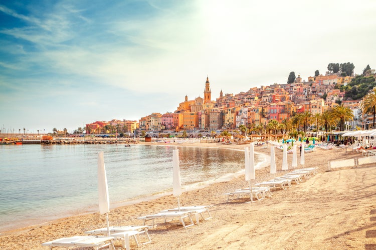 Sunny beach with chairs and umbrellas in Menton, French Riviera, France