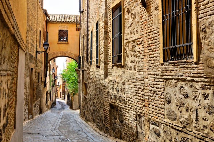 photo of view of  Historic street with archway in the Old Town of Toledo, Spain