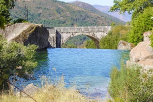 photo of Poço da Broca waterfall in Serra da Estrela Natural Park, Barriosa, municipality of Seia in Portugal, with a viewpoint in the foreground, at the end of a spring day.