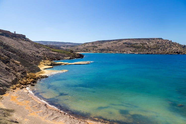 Photo of Bay of Gnejna, Manikata, Malta with blue sky.