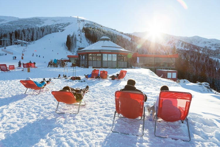 photo of view of CHOPOK, SLOVAKIA - JANUARY 12, 2017: Skiers and snowboarders taking a rest in chairs near apres ski bar near Chopok, January 12, 2016 in Jasna - Slovakia.