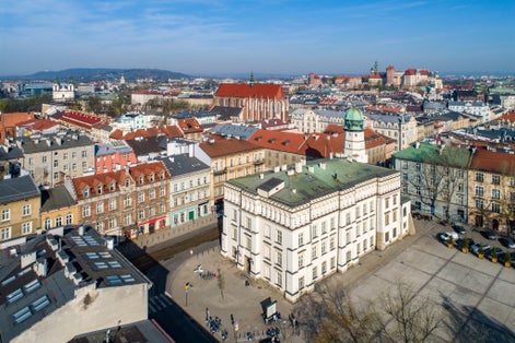 Old town hall of Kazimierz town, then the Jewish district of Krakow, Poland, situated at Wolnica Square. Wawel Castle, St Catherine church, Skalka church and monastery in the background. Aerial view
