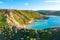 Nature landscape of Ghajn Tuffieha bay. Aerial view. People on the hill. Clear blue sky, sea and green grass. Malta island