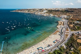 Photo of aerial view of seaside cliffs, colourful houses and streets of Qawra town in St. Paul's Bay area in the Northern Region, Malta.