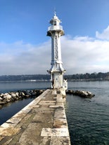 Geneva skyline cityscape, French-Swiss in Switzerland. Aerial view of Jet d'eau fountain, Lake Leman, bay and harbor from the bell tower of Saint-Pierre Cathedral. Sunny day blue sky.