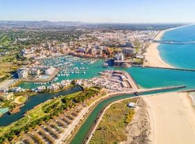 Photo of wide sandy beach in white city of Albufeira, Algarve, Portugal.