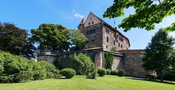 Photo of scenic summer view of the German traditional medieval half-timbered Old Town architecture and bridge over Pegnitz river in Nuremberg, Germany.