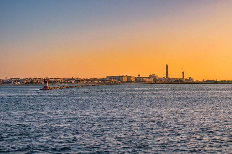 Breakwater of Aveiro estuary with buildings and Barra lighthouse in the horizon at golden hour, Gafanha da Nazaré PORTUGAL