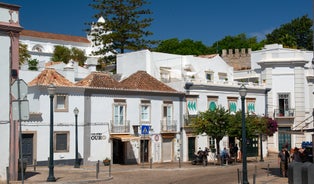 Photo of aerial cityscape of beautiful Tavira with roman bridge over Gilao river in the evening, Algarve, Portugal.