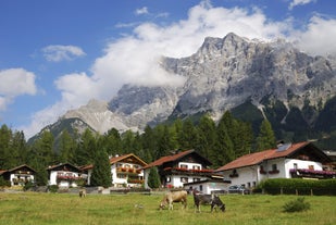 Photo of a view of the Alps from the Ehrwald, a town on the border of Germany and Austria with picturesque meadows surrounded by towering mountain ranges, including the Zugspitze.