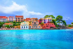 Photo of white boat in crystal clear blue sea water, Argostoli, Greece.