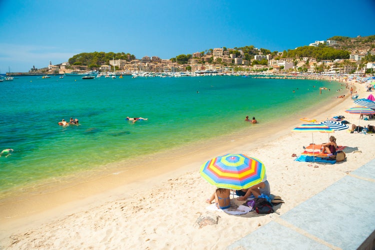 Colorful umbrellas on Puerto de Soller, Port of Mallorca island in balearic islands, Spain. Beautiful picture of people resting on the beach on bright summer day.