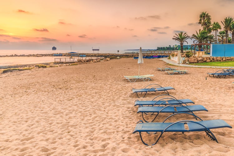 Photo of scenic sunset on the beach in the town of Paphos, Cyprus, beautiful view of the Mediterranean Sea and the coastline.