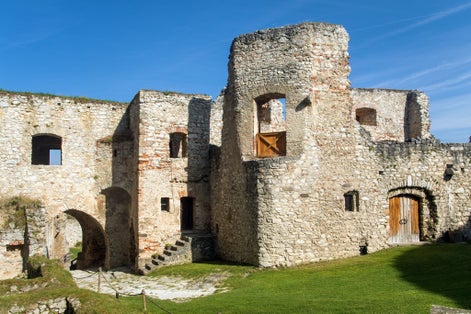 Photo of Rabi castle, largest medieval fortress ruin in the Czech Republic with concentric walls and round towers.