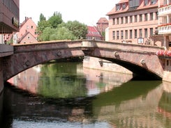 Photo of scenic summer view of the German traditional medieval half-timbered Old Town architecture and bridge over Pegnitz river in Nuremberg, Germany.