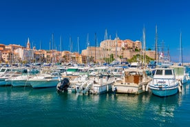 Photo of aerial view from the walls of the citadel of Calvi on the old town with historic buildings and bay with yachts and boats, Corsica, France.