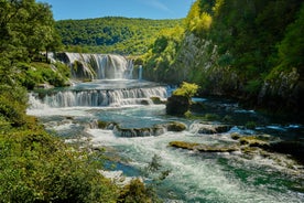 Photo of beautiful waterfalls of Plitvice Lakes (Plitvička jezera) in Plitvice National Park on a bright summer day with blue sky and clouds, municipality of Korenica, Croatia.