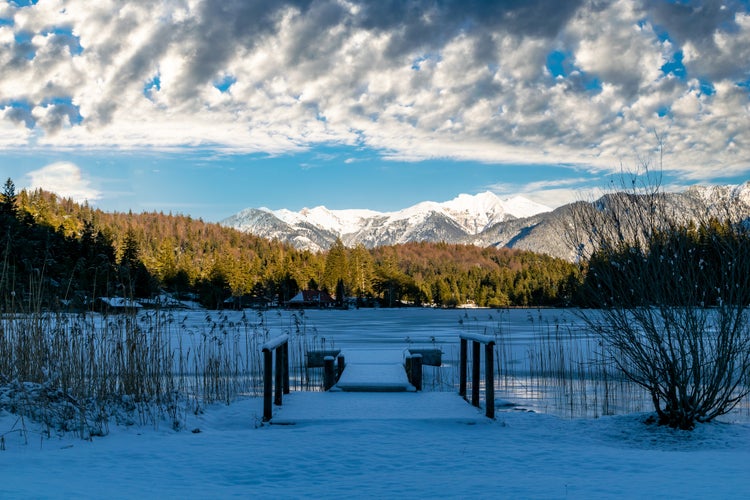 Photo of the frozen Lautersee and the snowy Alps in Mittenwald, Germany.