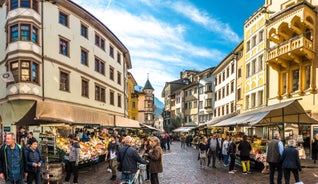 Photo of Italy Piazza Maggiore in Bologna old town tower of town hall with big clock and blue sky on background, antique buildings terracotta galleries.