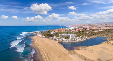 photo of landscape with Maspalomas town and golden sand dunes at sunrise, Gran Canaria, Canary Islands, Spain.