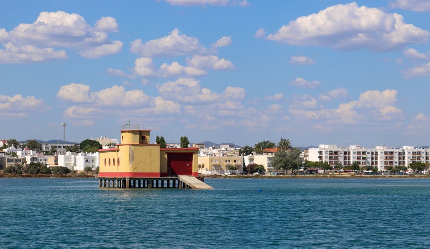 Photo of Landscape view from Fuseta, an old Portuguese city in the municipality of Olhão in the district of Faro, Algarve. View of the historical yellow life-guard building in Fuseta.