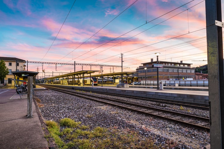 Photo of colorful sky at a Swiss railway station. Mendrisio, example of public transport on rail, Canton Ticino, Switzerland.