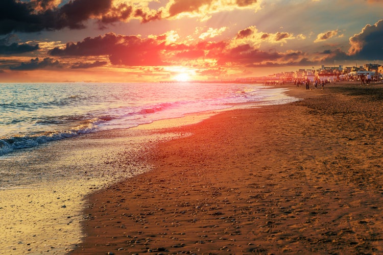 Twilight sea sunset landscape. Mediterranean sand beach of Italian Lido di Ostia in evening with beautiful sun near water horizon.