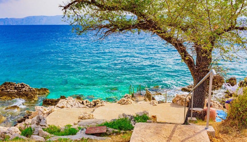 Beautiful Mediterranean landscape promenade in Novi Vinodolski Croatia behind a tree.