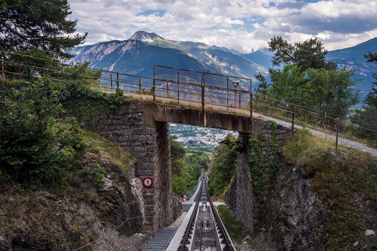 Photo of Landscape of Swiss Alps. Mountain, Sierre city, bridge and funicular trail in Switzerland. Crans Montana, Valais Canton, Switzerland.