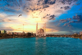 Touristic sightseeing ships in Golden Horn bay of Istanbul and mosque with Sultanahmet district against blue sky and clouds. Istanbul, Turkey during sunny summer day.