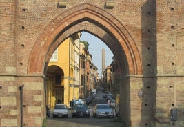 Photo of Italy Piazza Maggiore in Bologna old town tower of town hall with big clock and blue sky on background, antique buildings terracotta galleries.