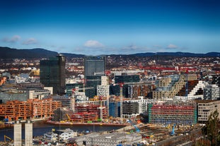 Photo of landscape with mountains, river and buildings in Lillehammer town, Norway.