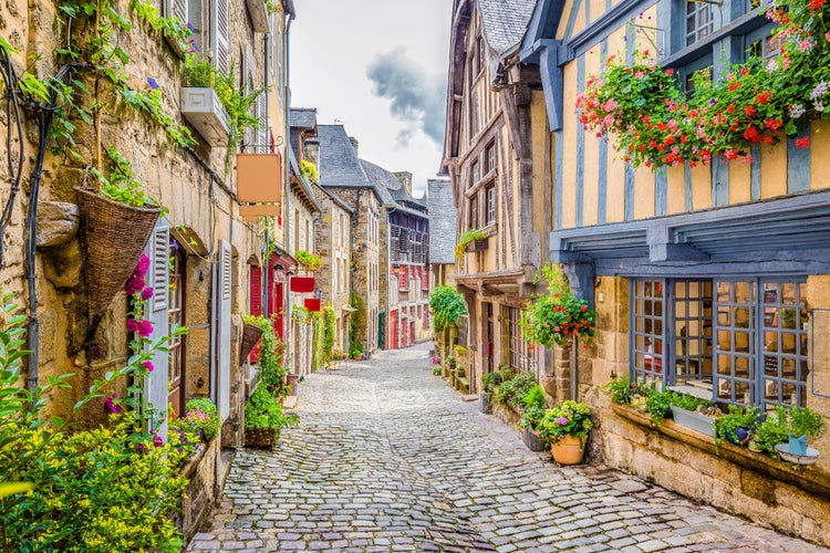 photo of view of Beautiful view of scenic narrow alley with historic traditional houses and cobbled street in an old town, Dinan, France.