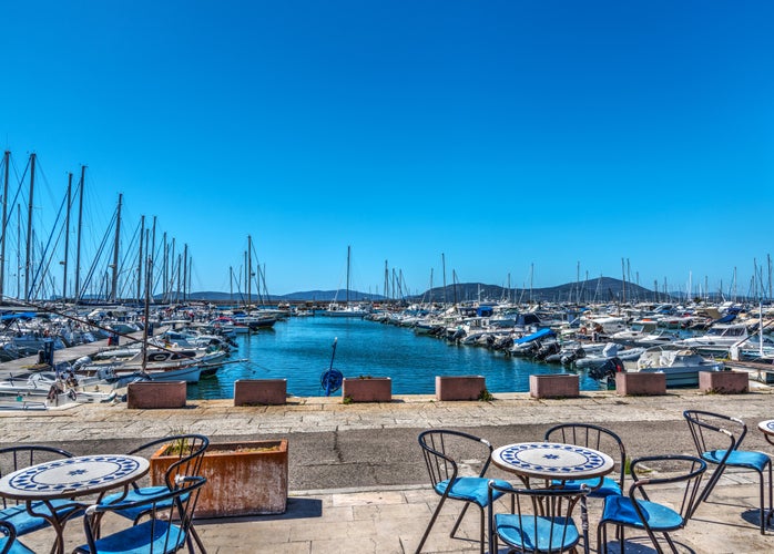 Tables and chairs by Alghero harbor. Sardinia, Italy