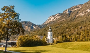 photo of Elevated, scenic view of the town of Bischofswiesen, Bavaria, Germany. The Watzmann Mountain, part of the Bavarian Alps rises into a majestic skyline. A green, spring landscape set in the valley.