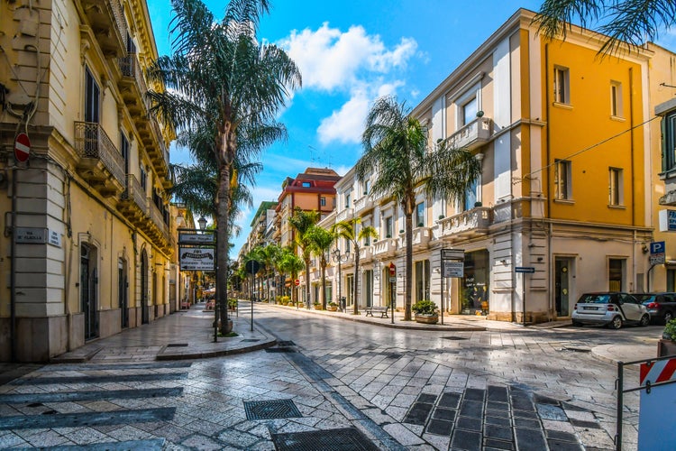 Empty streets and closed shops and cafes on a summer morning on the main street, Corso Umberto, through the town center of the coastal city of Brindisi, Italy.